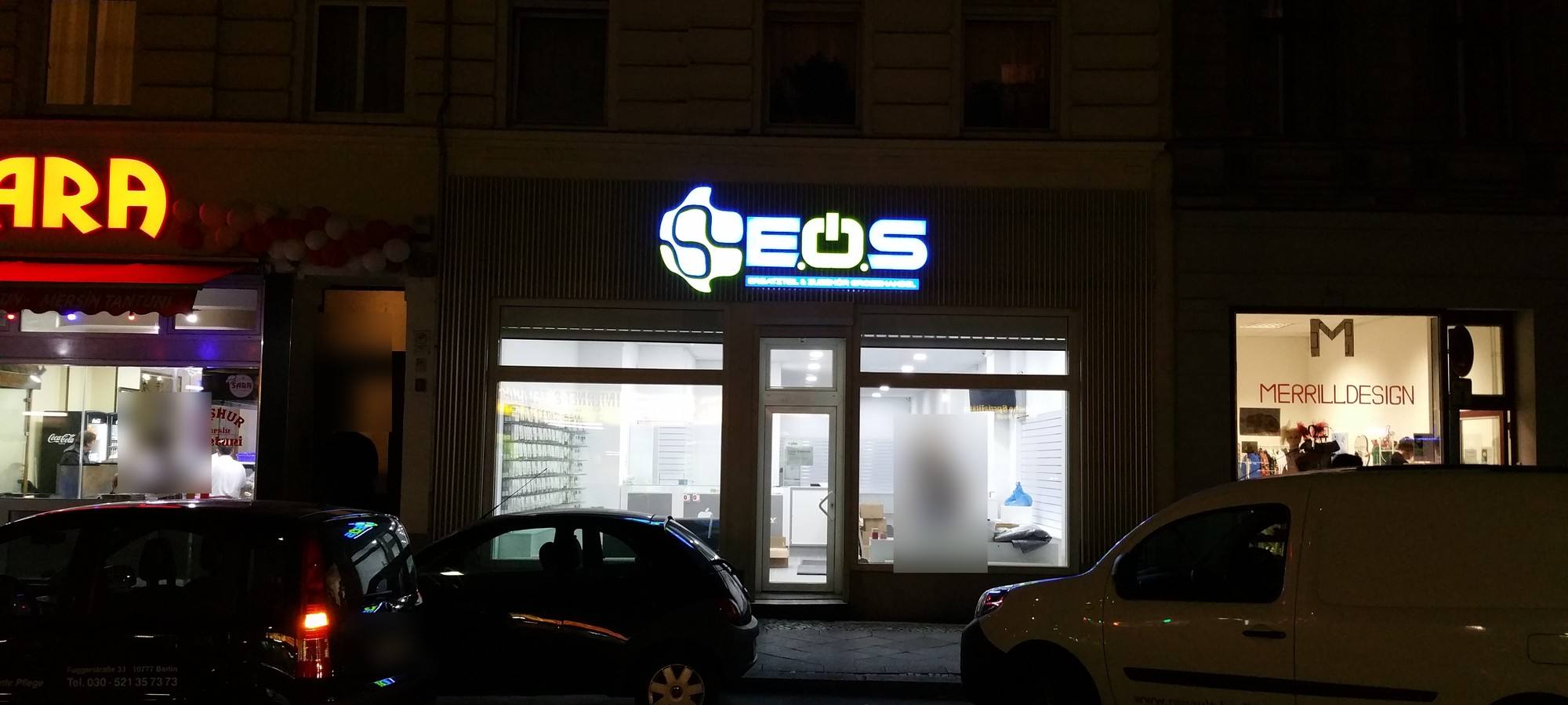 Dieselben Buchstaben eine Woche später an der Fassade: Logo „EOS“ leuchtet blau-weiß bei Nacht