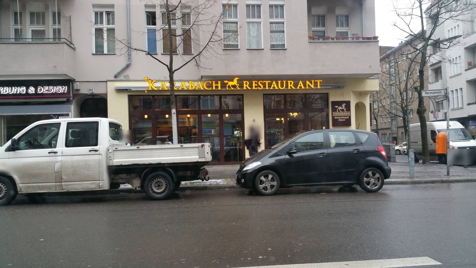 Restaurantfassade mit goldenem Schriftzug „Karabach Restaurant“ und Pferdelogo an einer Berliner Straße bei Tag