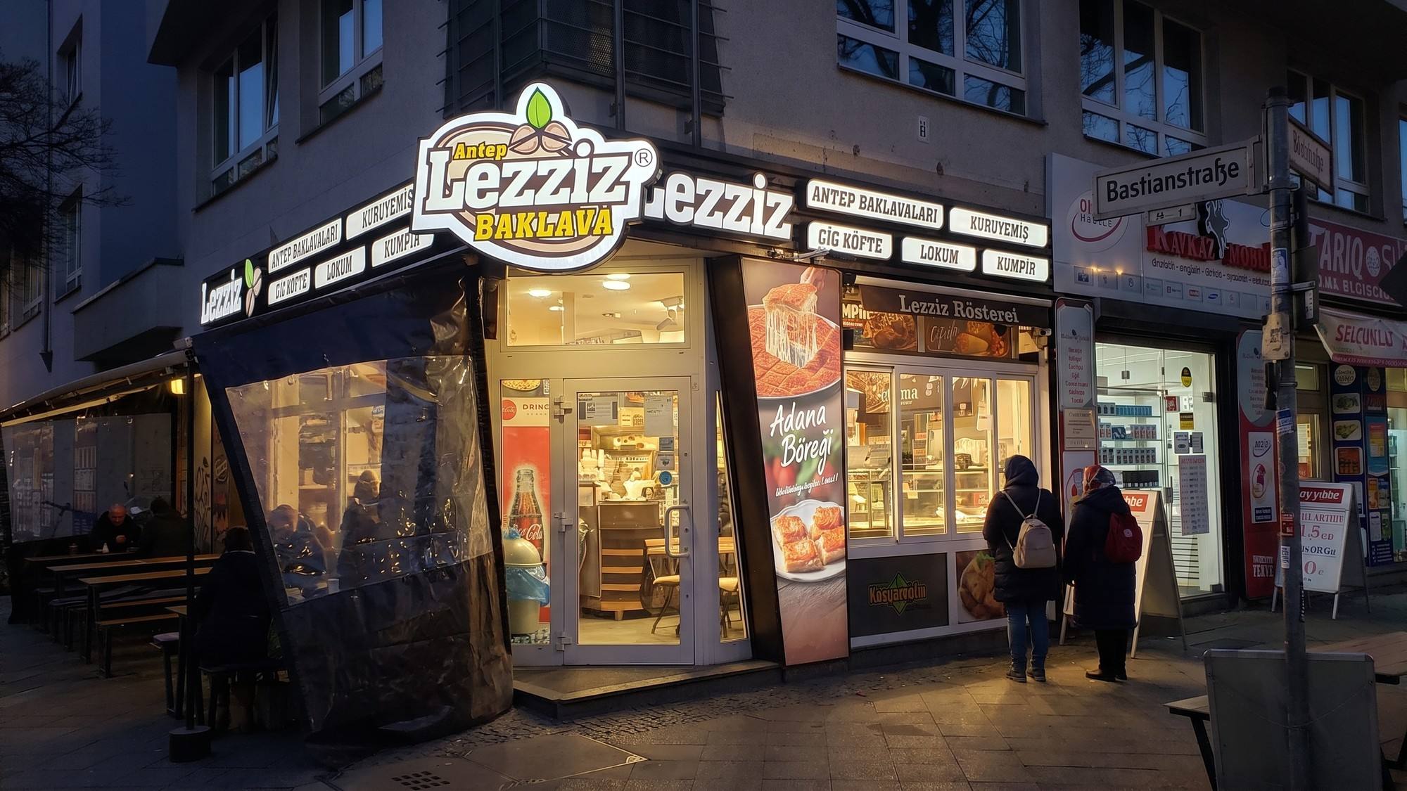 Dieselbe Fassade als Nachtansicht visualisiert: Logo, Schriftzug und Leuchtkästen leuchten